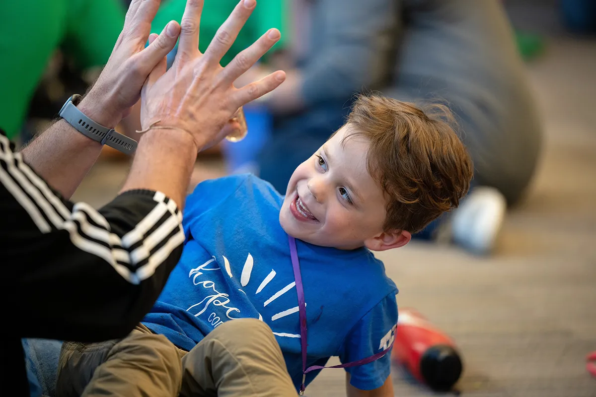 Youth clapping hands with practitioner